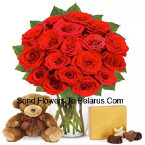 11 roses rouges avec quelques fougères dans un vase en verre accompagnées d'une boîte de chocolats importée et d'un mignon ours en peluche brun de 12 pouces de hauteur