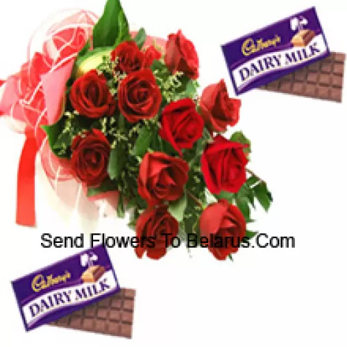 Um buquê de 11 rosas vermelhas com complementos sazonais, juntamente com chocolates sortidos da Cadbury