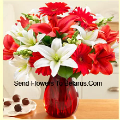 Red Gerberas, White Lilies, Red Lilies And Other Assorted Flowers Arranged Beautifully In A Glass Vase