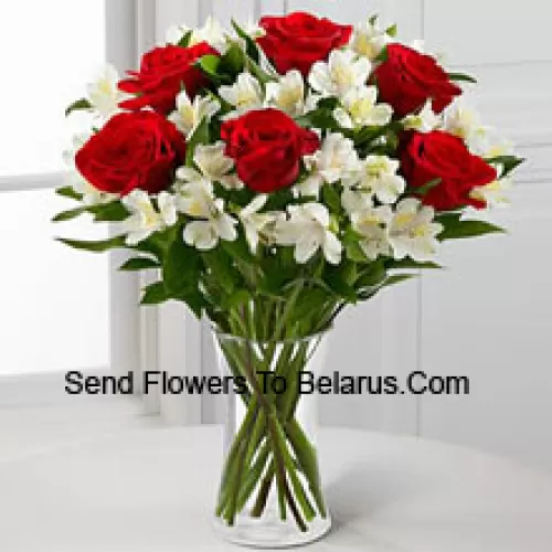 7 Roses rouges avec des fleurs blanches assorties et des remplisseurs dans un vase en verre