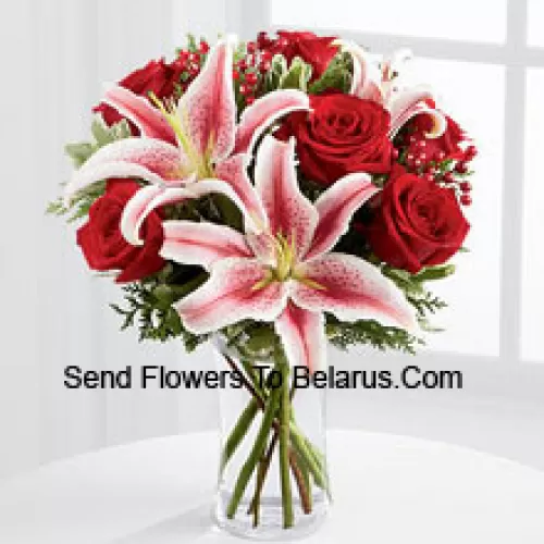 Ce bouquet est un affichage simplement magnifique de glamour saisonnier auquel ils ne pourront pas résister. Les riches roses rouges sont associées à la beauté éblouissante des lys Stargazer, accentuées par des verdure de vacances, des jets de baies et un ruban de satin bordeaux pour un look élégant. Disposé dans un vase en verre transparent, ce bouquet ajoutera à la magie et à l'émerveillement de leurs festivités de vacances. (Veuillez noter que nous nous réservons le droit de substituer tout produit par un produit approprié de valeur égale en cas de non disponibilité d'un certain produit)